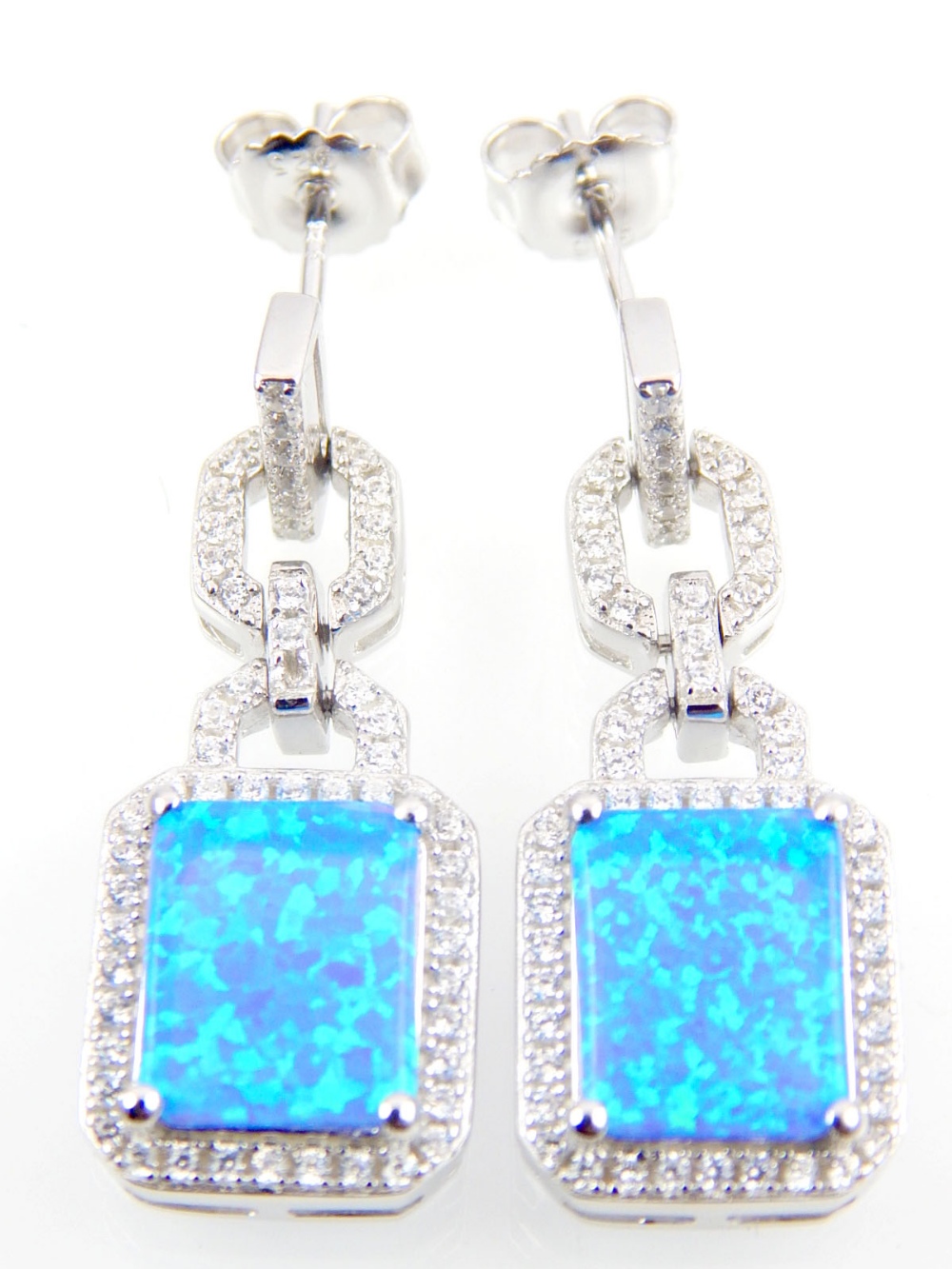 A pair of silver and cubic zirconia drop earrings set with a rectangular shaped blue opalite stone.