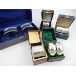 Eight cased silver napkin rings, George V and later, includes three pairs,