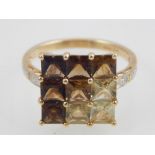 10ct yellow gold topaz and citrine nine stone ring, square form with diamond shoulders.