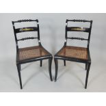 Pair of Regency gilt metal mounted ebonised dining chairs with turned top rails and spars and cane