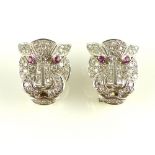 Pair of diamond and ruby ear clips, modelled as cougar heads, 15.
