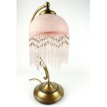 Art Nouveau style gilt metal table lamp with tasselled glass shade.