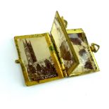 Miniature glass case containing enamelled miniature book of sepia photographs of Taunton,