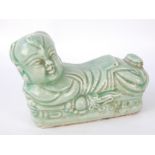 Chinese celedon desk weight, in the form of a child feigning to be a temple lion, stamp to base,