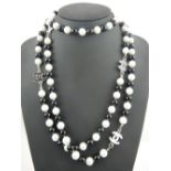 A string of alternate black glass and imitation white pearls necklace with silver CC design clasp