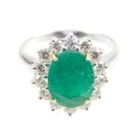 An 18ct white gold, emerald and diamond cluster ring, emerald 3ct, diamonds 1ct total.