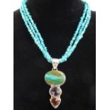 Necklace comprising three strands of rough cut turquoise beads with silver clasp and silver mounted