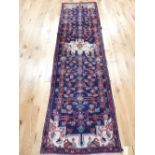 Persian runner, central cream medallion, decorated with stylised floral design over indigo ground,