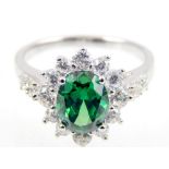 Silver ring set with oval green stone surrounded by white cubic zirconia