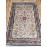 Silk carpet, traditional floral Qum design over cream ground within indigo border, 292cm l,