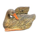 Carved hardwood model of a duck, preening itself with one wing raised,