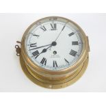 A good vintage Smiths brass cased wall mounted marine clock with Roman chapters on a white dial