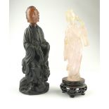 Chinese rose quartz caved figure, standing holding a fan, together with a carved ebonised figure