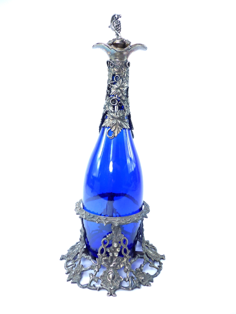 A blue glass and white metal mounted claret jug, stopper and stand, 36cm h