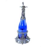 A blue glass and white metal mounted claret jug, stopper and stand, 36cm h