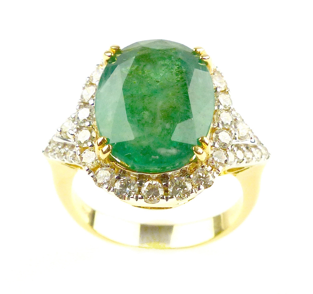 Emerald oval cut dress ring with a diamond surround, emerald of 6.93ct, diamonds 0.