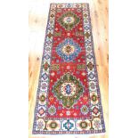 Kazak runner, three large geometric medallions to centre over red and ivory ground,