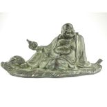 Bronze figure of Buddha, reclining of a leaf with an overflowing sack of food at his feet, 25cm wide