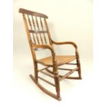 Stained beech rocking chair, spindleback, rattan seat, turned supports and stretcher,