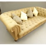 Chesterfield sofa, triple seat, buttonback roll arms, turned legs and brass castors, c 1890,