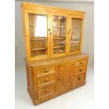 Pine dresser, triple glazed doors over six drawers flanking a panelled door cupboard, bun handles,