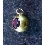 An antique garnet mourning locket in high carat yellow gold, modelled as a sphere,
