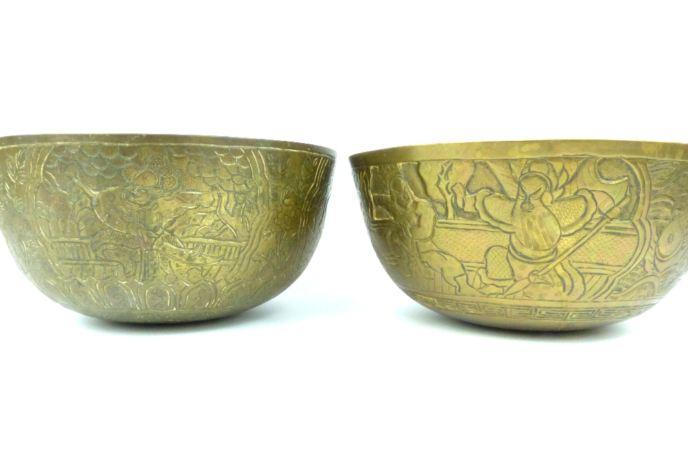 Pair of heavy Chinese brass bowls decorated with warriors, character marks to underside,