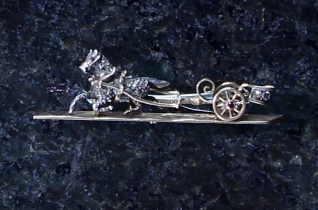 A jewelled horse and chariot bar brooch in 15ct yellow gold, the horse set with round cut diamonds,