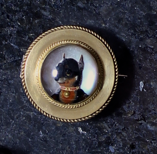 An antique Essex Crystal brooch depicting a chihuahua with red and gold collar, in yellow gold,