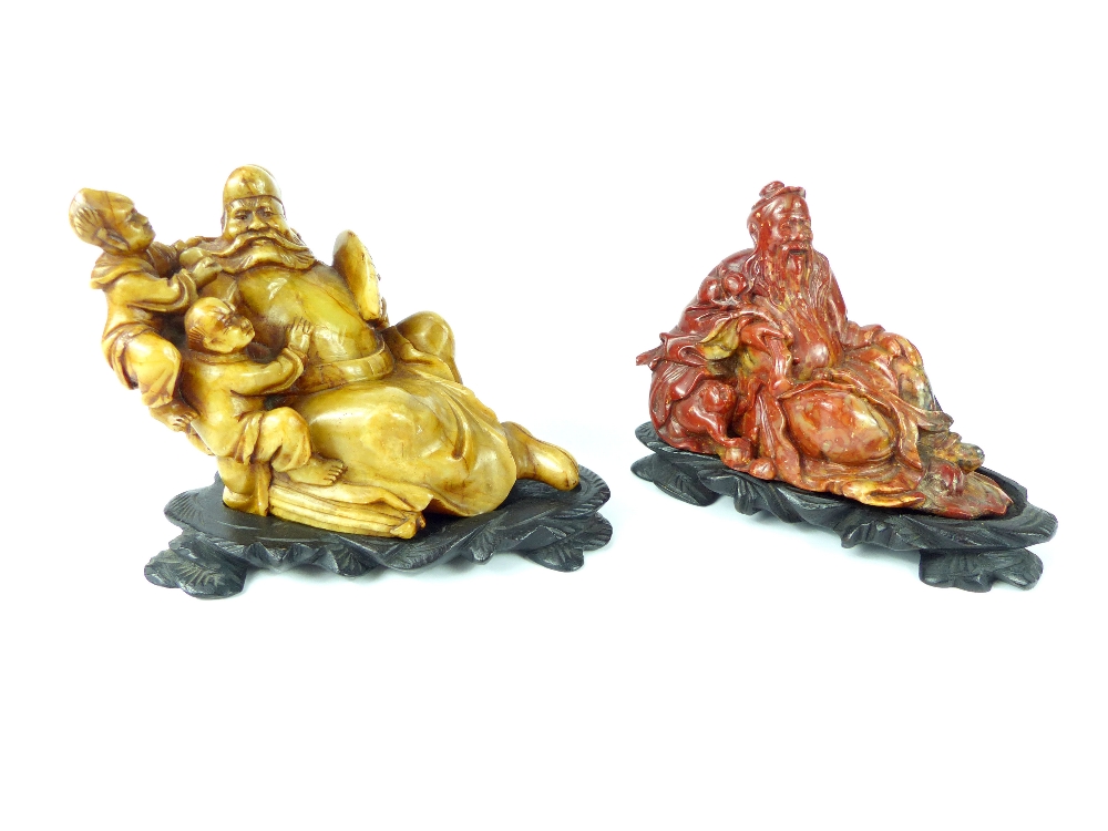 Two Chinese antique carved soapstone figures of bearded immortals, each signed on their bases,