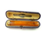 An antique gold mounted amber cigarette / cigar holder, in case. Length 6.6cm. Gross Weight 4.6g.