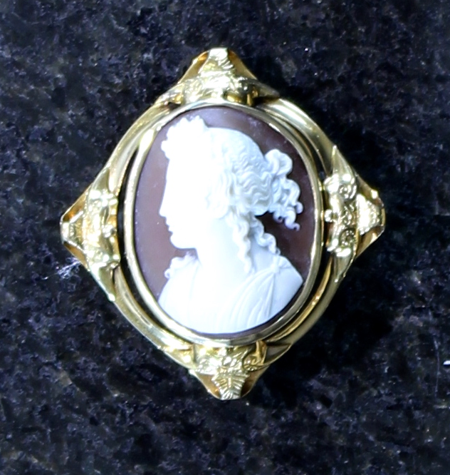 An antique cameo brooch in yellow gold, finely carved to depict a woman in Grecian dress.