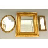 A rectangular gilt framed bevelled mirror, an oval gilt framed mirror and another,