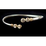 White metal torc bangle, the ends set with cubic zirconia stones within gilt wire, 4g