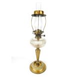 A victorian oil table lamp with clear glass chimney over lobed glass reservoir raised on reeded