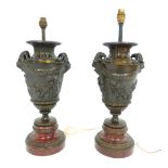 A pair of 20th C urn shaped bronze lamps, with neoclassical style rams' heads and putti at play,