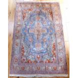 An old Persian part silk rug with double ended mihrab in pale washed indigo with brick red designs