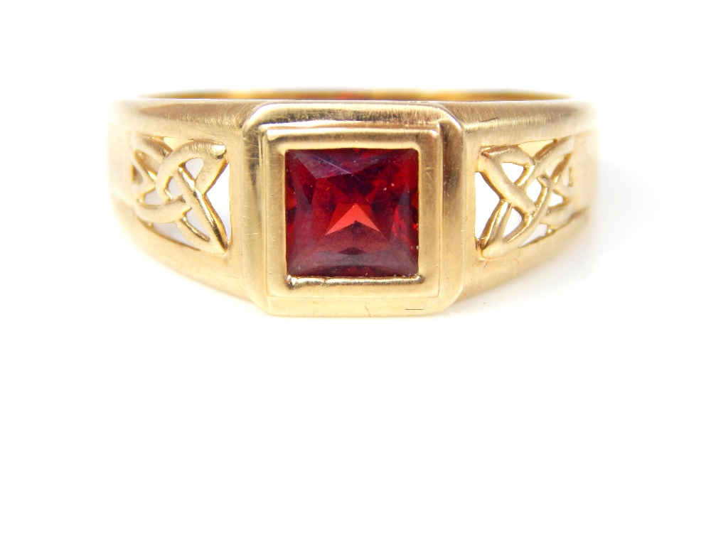 A gentleman's 9ct yellow gold garnet ring, set with square cut garnet with pierced Celtic design