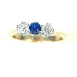 Ladies dress ring, sapphire flanked by diamonds, unmarked gold band.