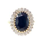 A 9ct yellow gold sapphire and diamond ring, the oval central central sapphire surrounded by