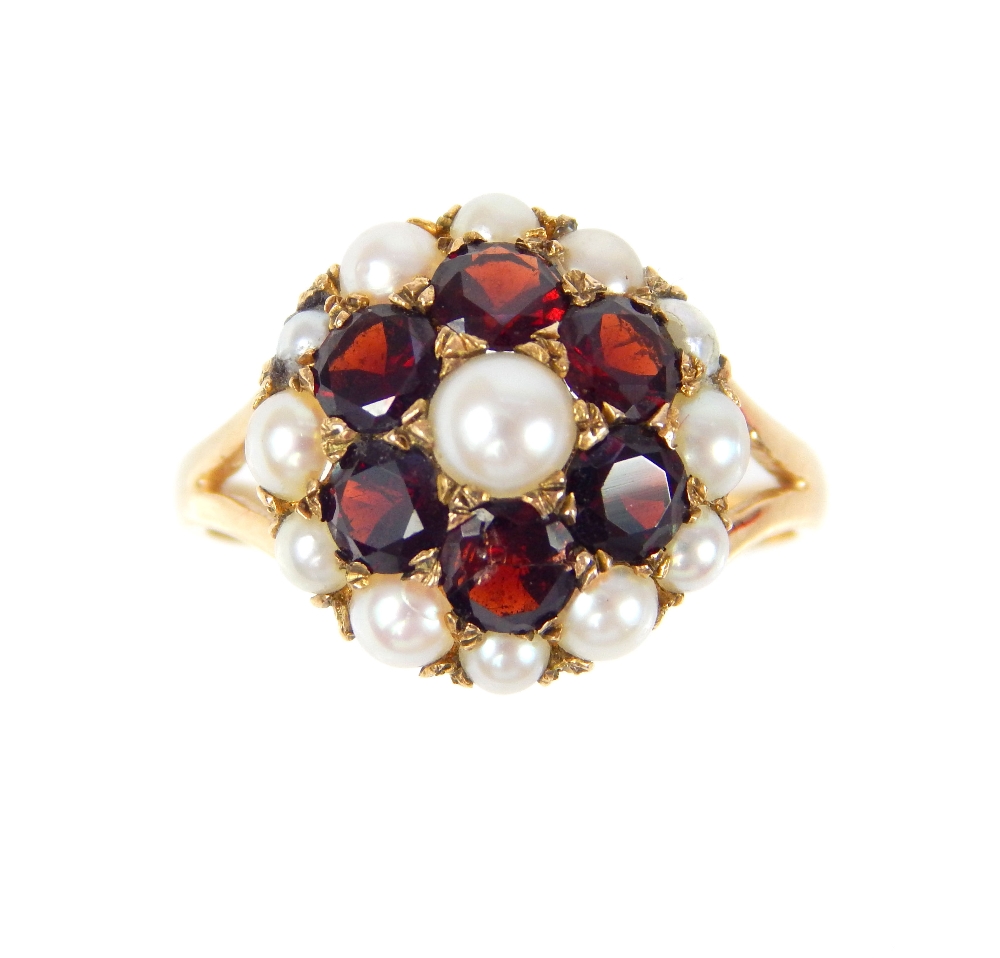 A 9ct yellow gold garnet and seed pearl flowerhead cluster ring, with pierced shoulders. - Image 2 of 4