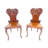 A pair of William IV mahogany solid seat hall chairs with carved rococo shaped backs & vacant