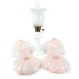 A 19th century milk glass oil lamp, 55cm high together with four 1930s pink glass hanging light