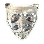 A silver pendant in the form of a leopards head, inset with ruby eyes, 3cm long