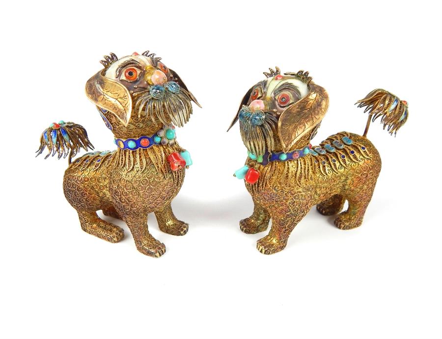 A 19th / early 20th century pair of silver gilt and enamelled Sino - Tibetan models of temple lions,