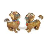 A 19th / early 20th century pair of silver gilt and enamelled Sino - Tibetan models of temple lions,