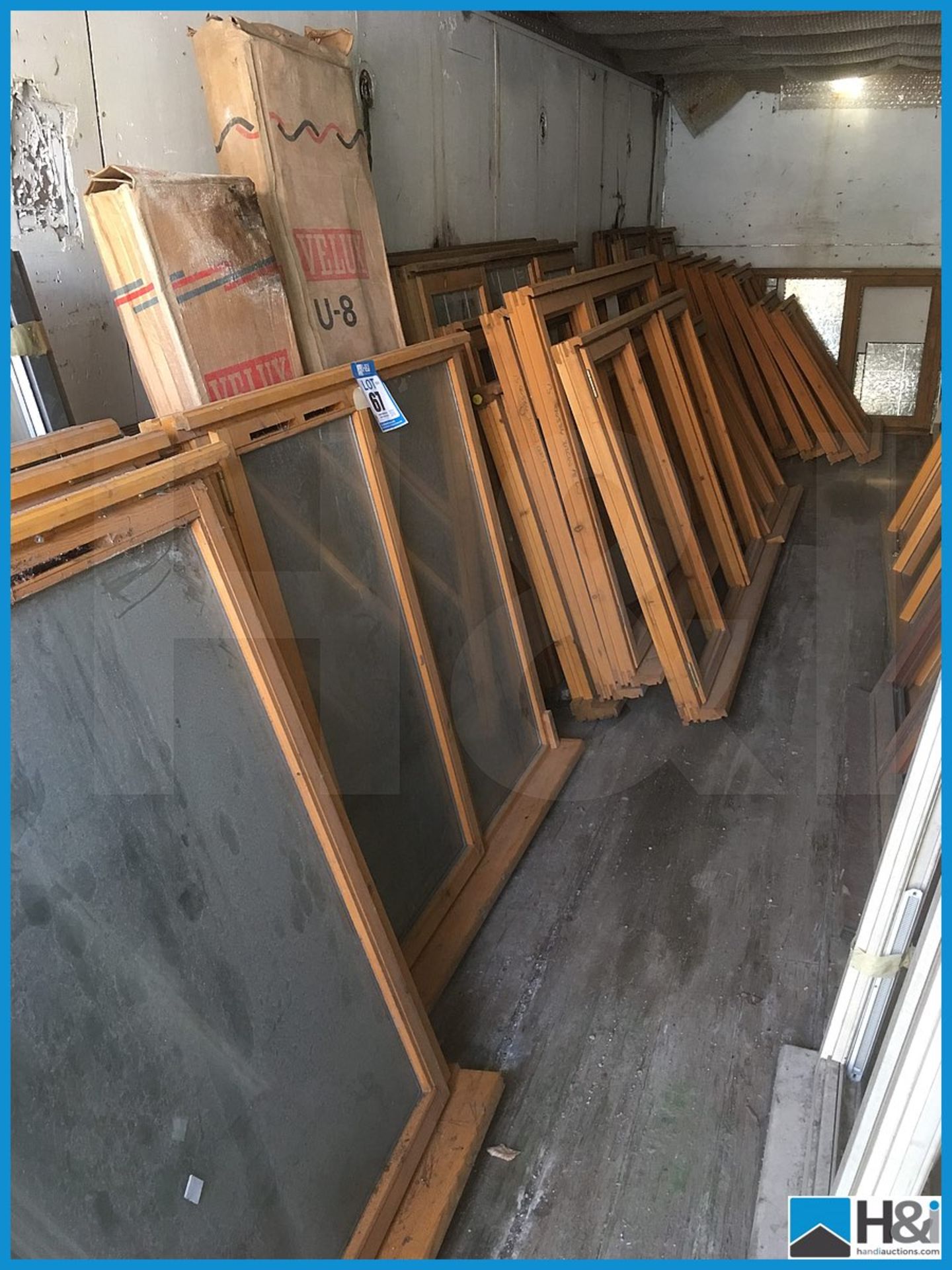 Huge quantity of unused wooden, glazed and unglazed window frames. Dusty appearance due to storage