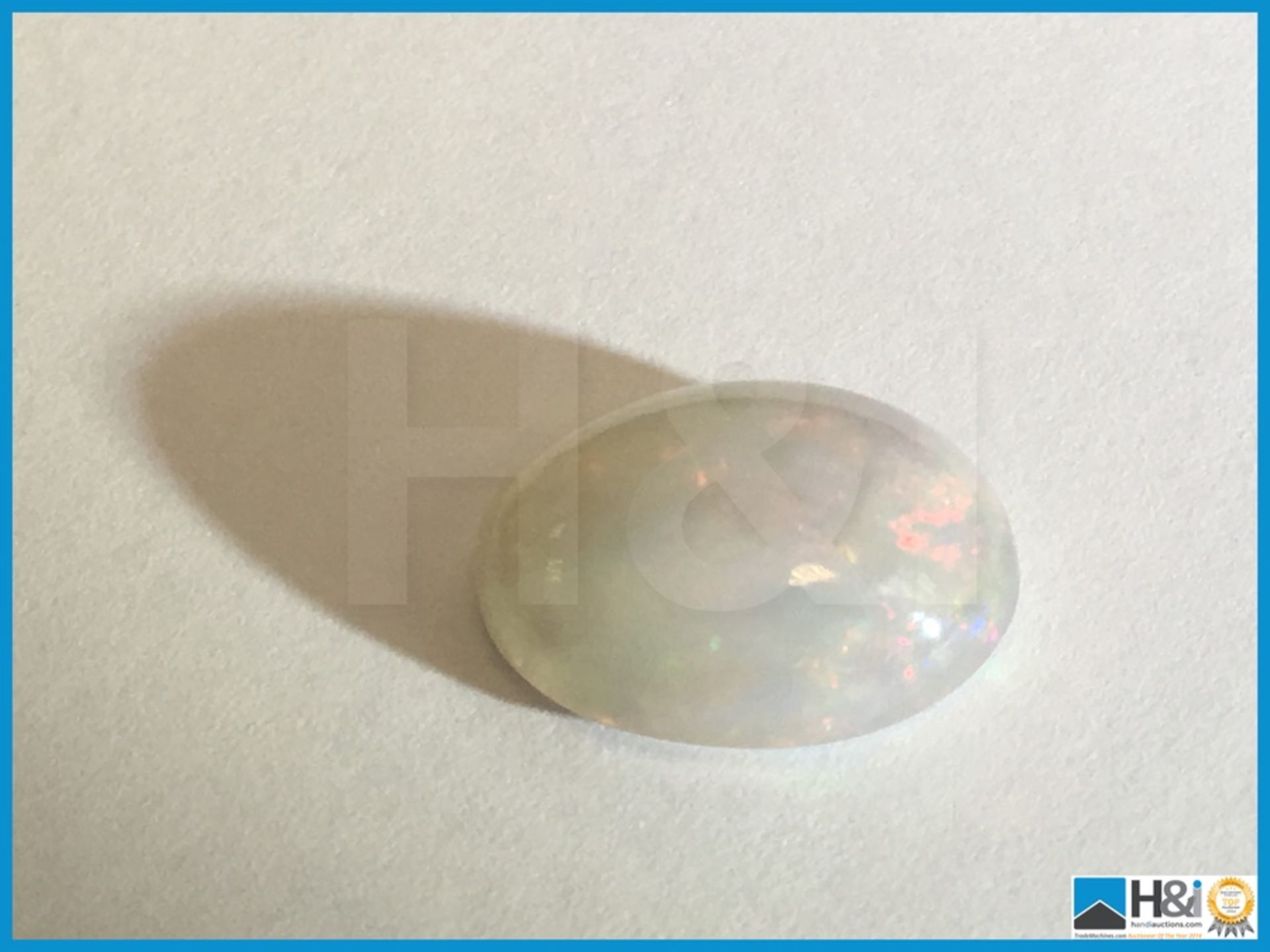 3.95ct Natural Opal. Oval Cabochon in white with play of colours. Size: 13.93x10.62x5.61mm.