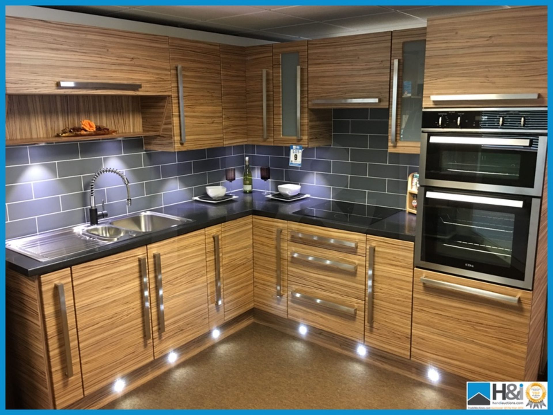 Stunning display kitchen finished in zebrano with black textured worktop, stainless steel 1.5 bowl