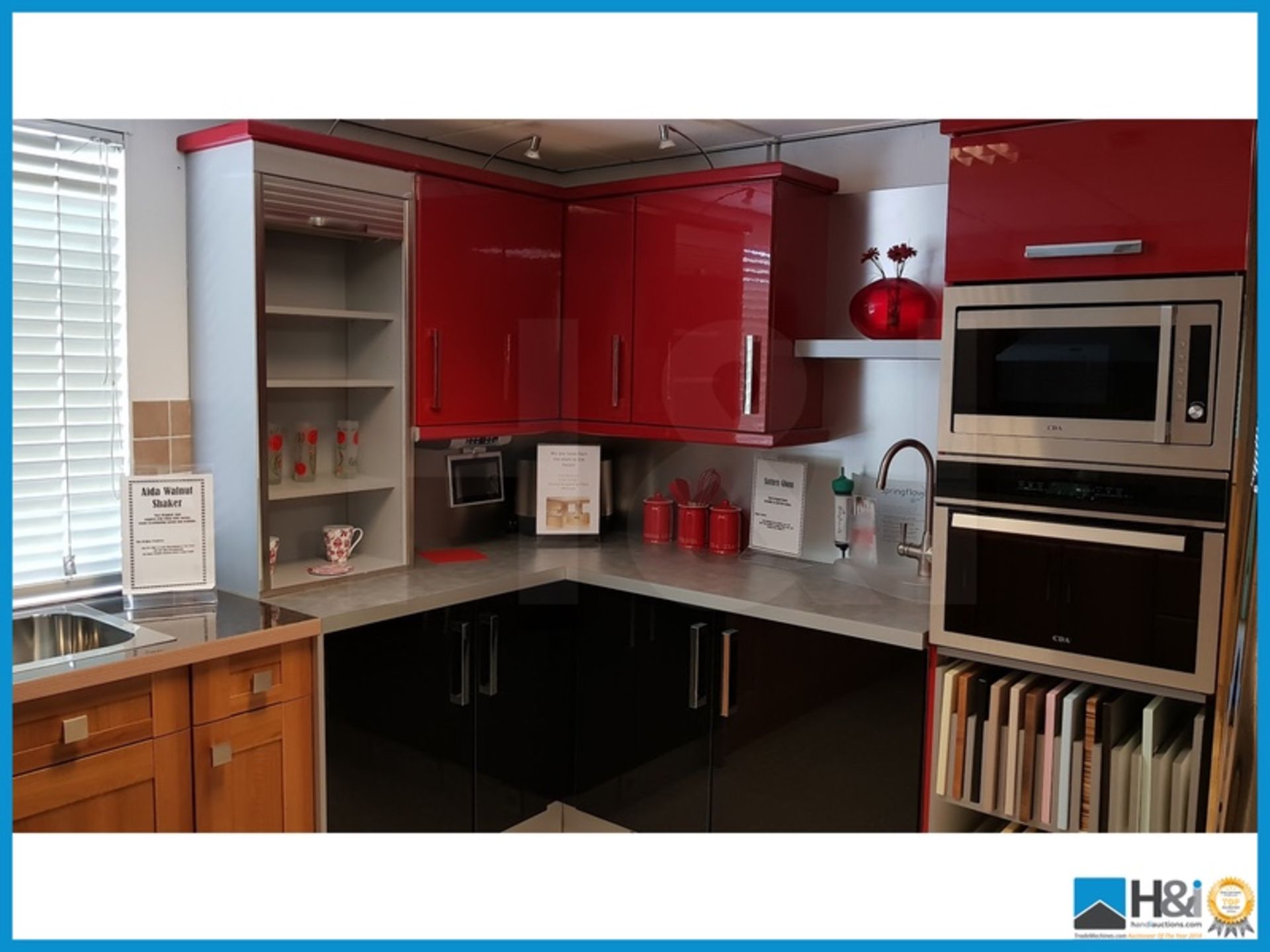 Red, silver and black display kitchen comprising tambour front storage unit, silver worktop and